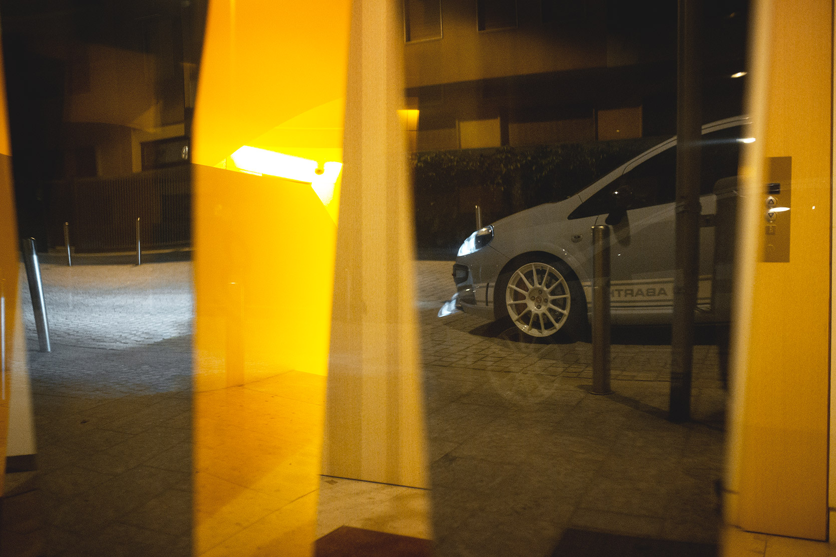 A Punto Evo Abarth Esseesse reflection on a door house in Milano