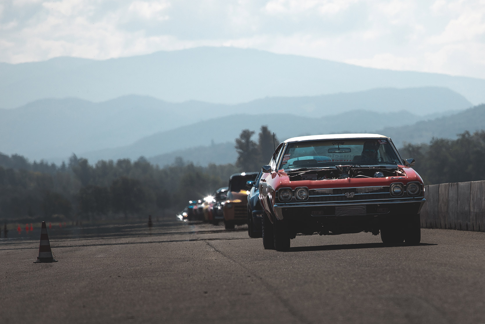 A Chevrolet Chevelle SS and other cars coming back to the parking lot at Rivanazzano Hills Race