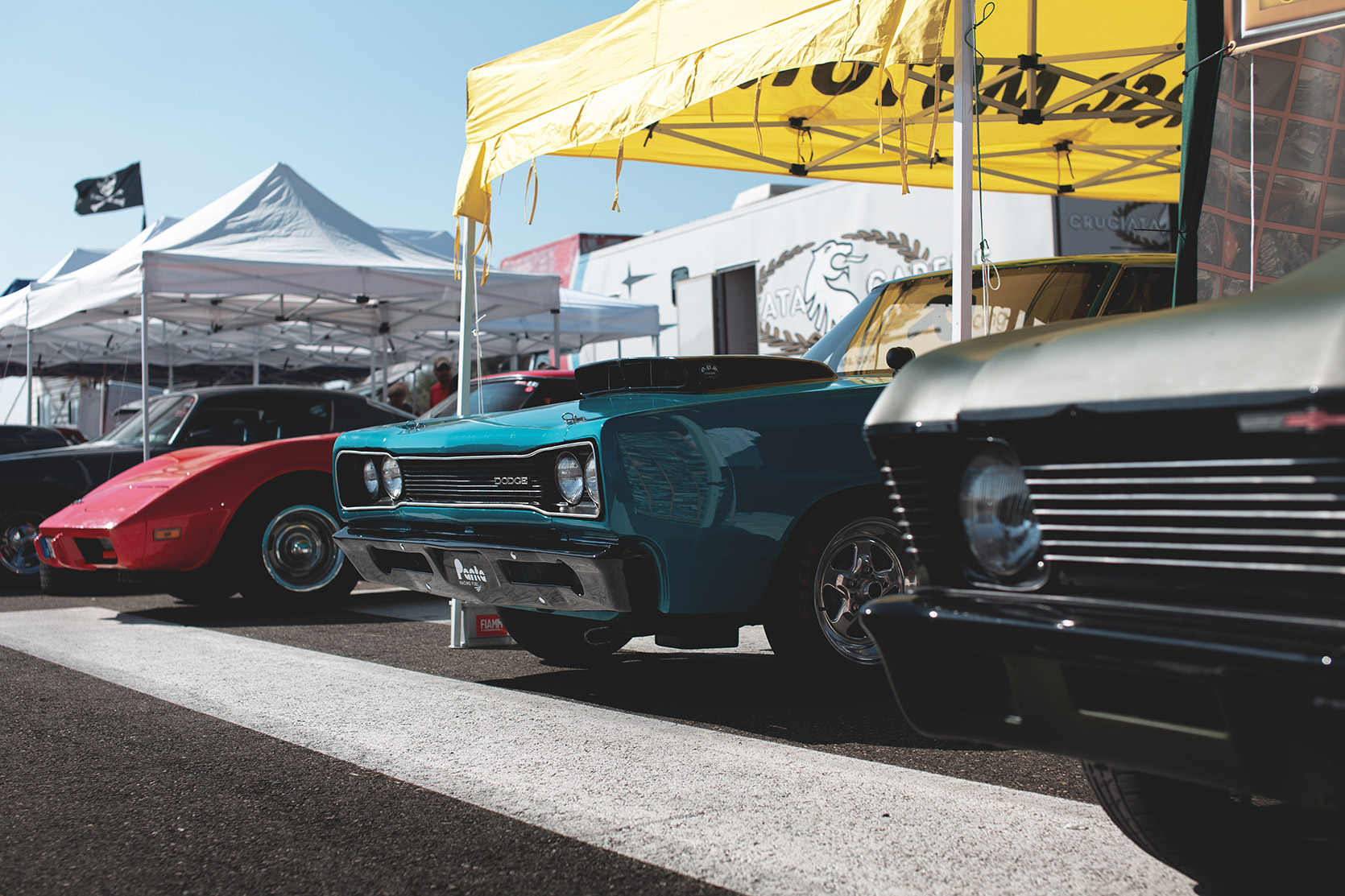A Chevrolet Corvette C3, a Dodge Charger R/T and a Chevrolet Nova in the parking at Rivanazzano Hills Race