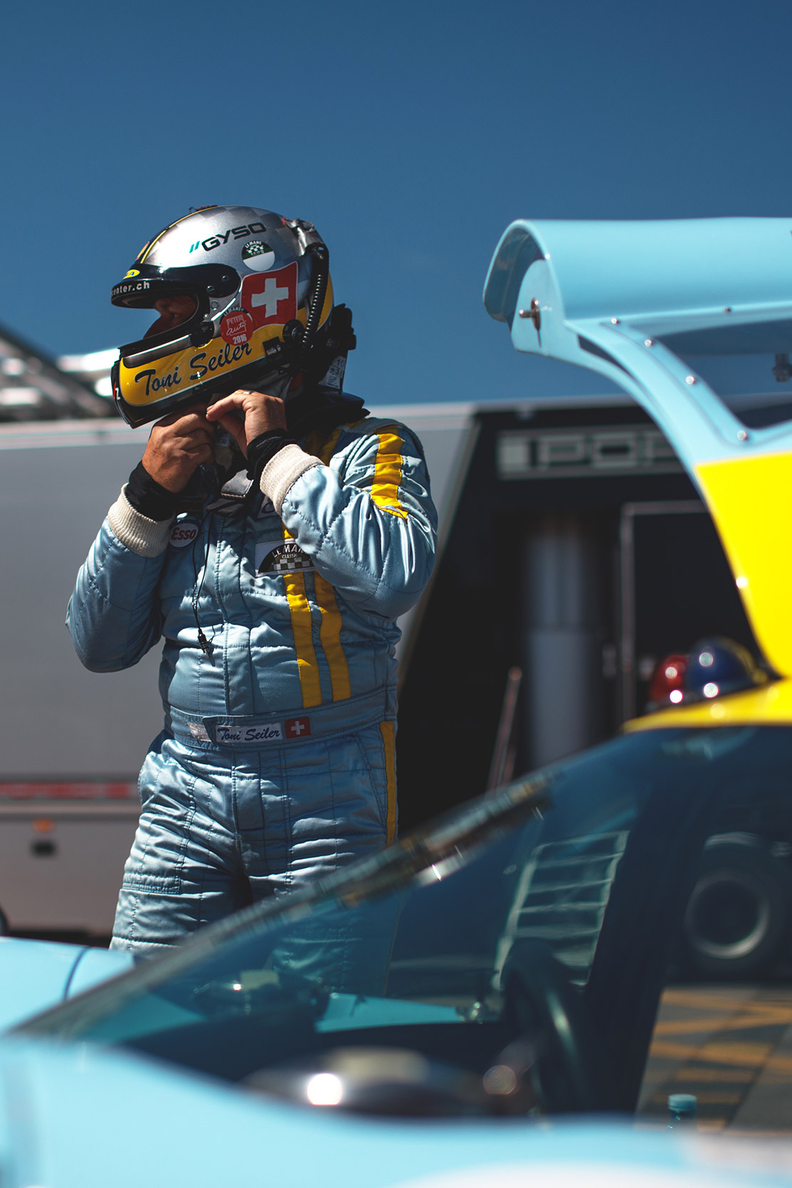 A racing driver is preparing near his car in the paddock of Autodromo Nazionale Monza at Monza Historic