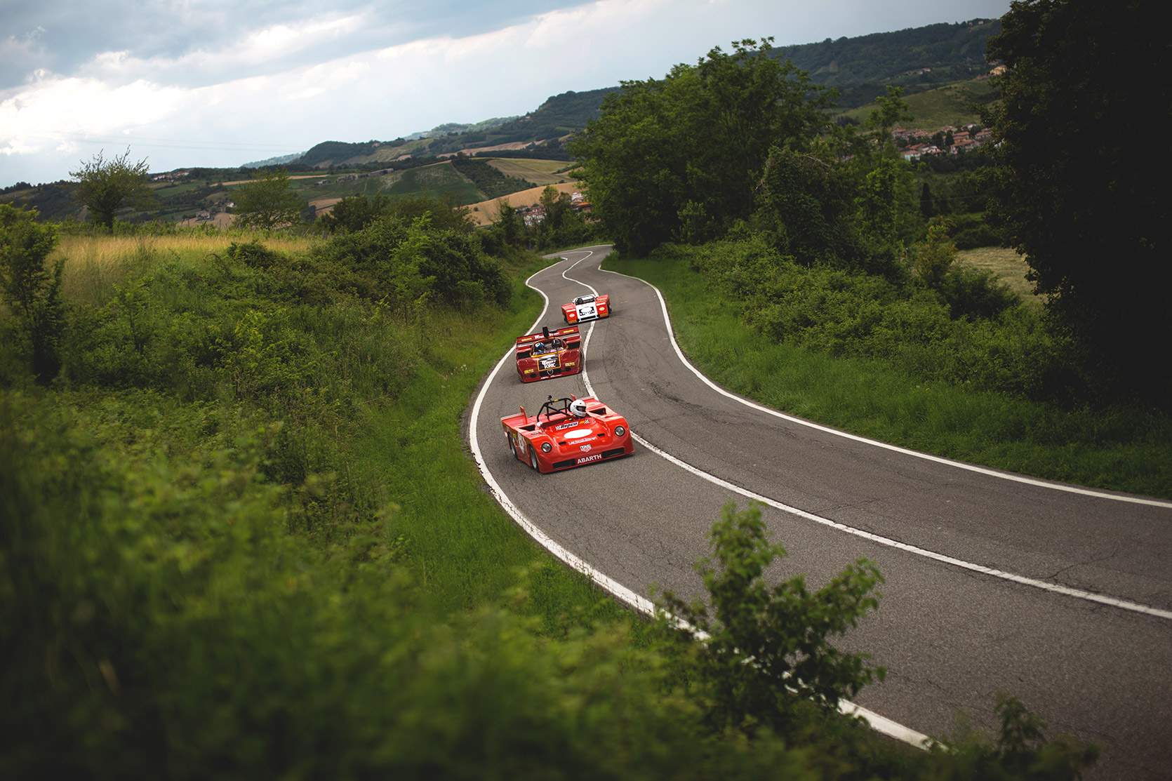 An Alfa Romeo 33 Daytona and an Abarth SE021 Sport in a row climbing the hill at Vernasca Silver Flag
