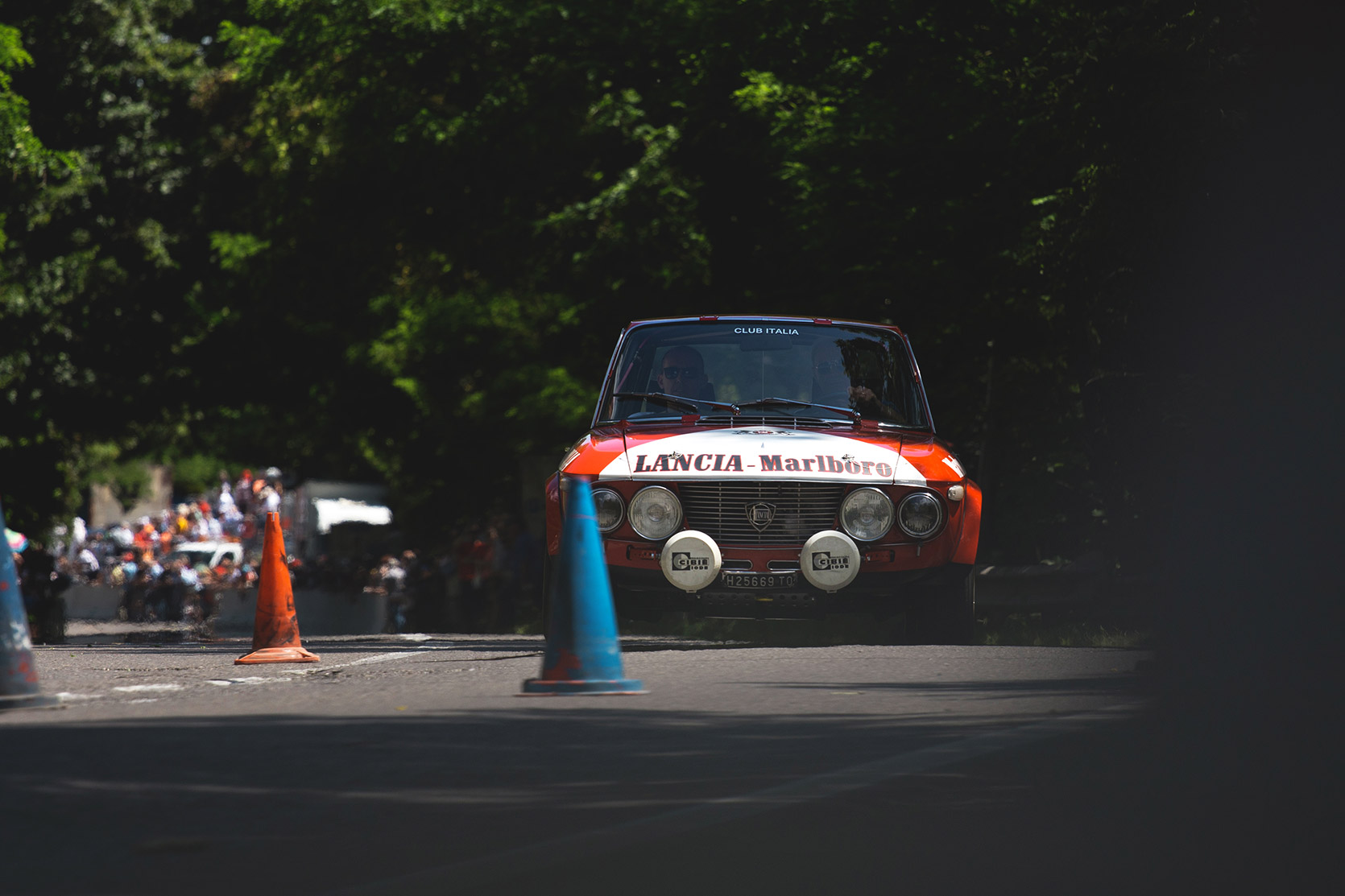 A Lancia Fulvia HF is doing a slalom between cones