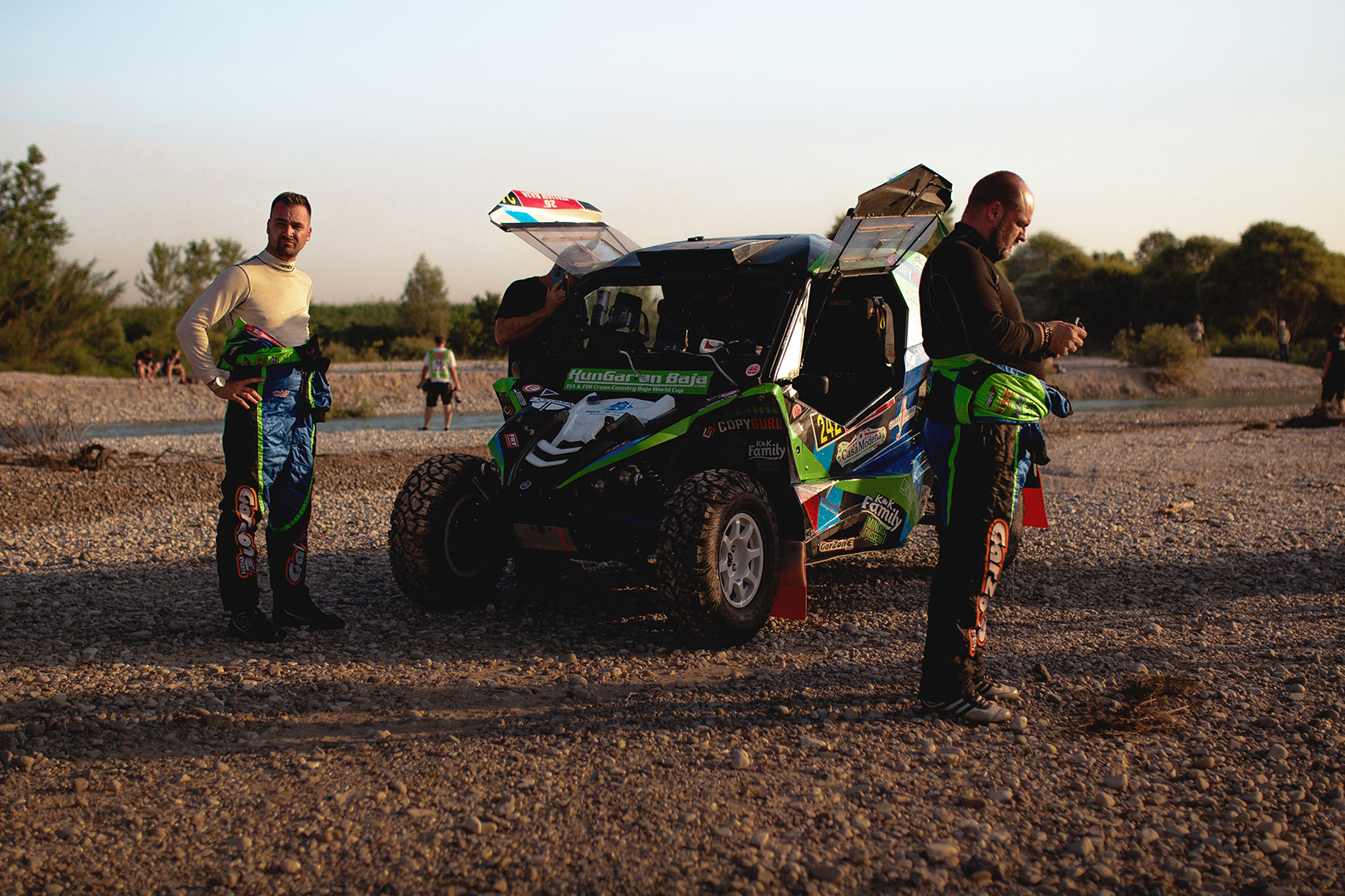 A team outside their ATV waiting for service at Italian Baja