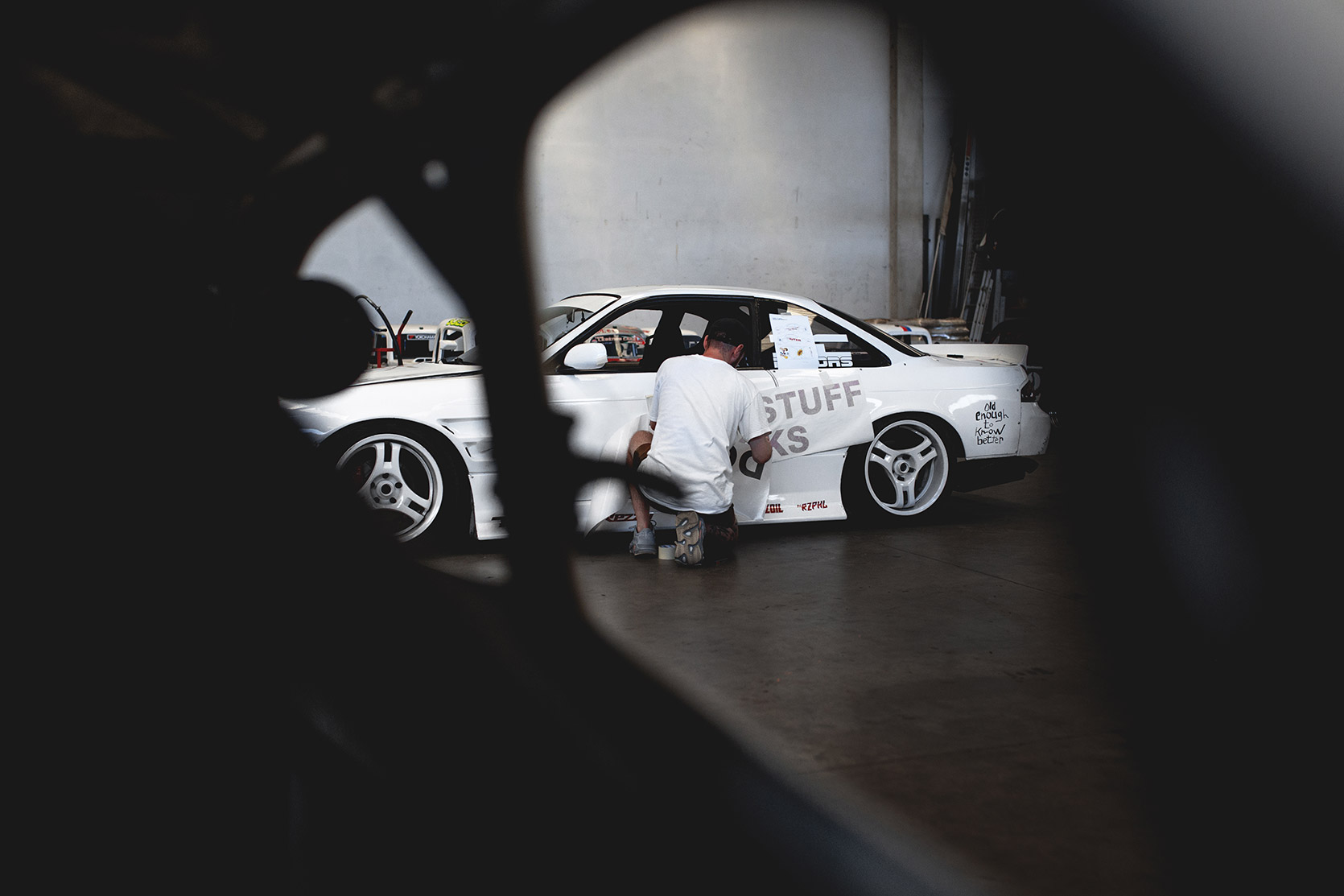 MH applying the Iuter sticker on Rizphel's Nissan Silvia S14 side in Castelletto Circuit di Branduzzo garage