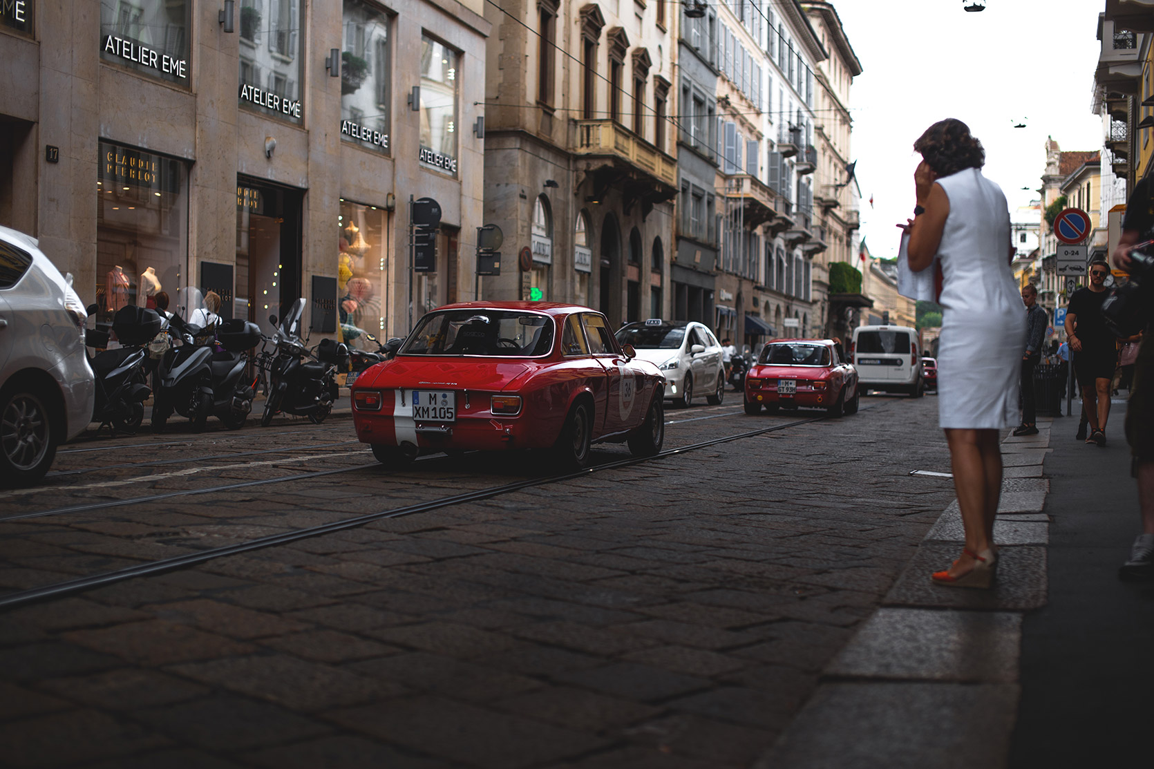Two Alfa Romeo Giulia Sprint going down the street in Milano at Modena 100 Ore
