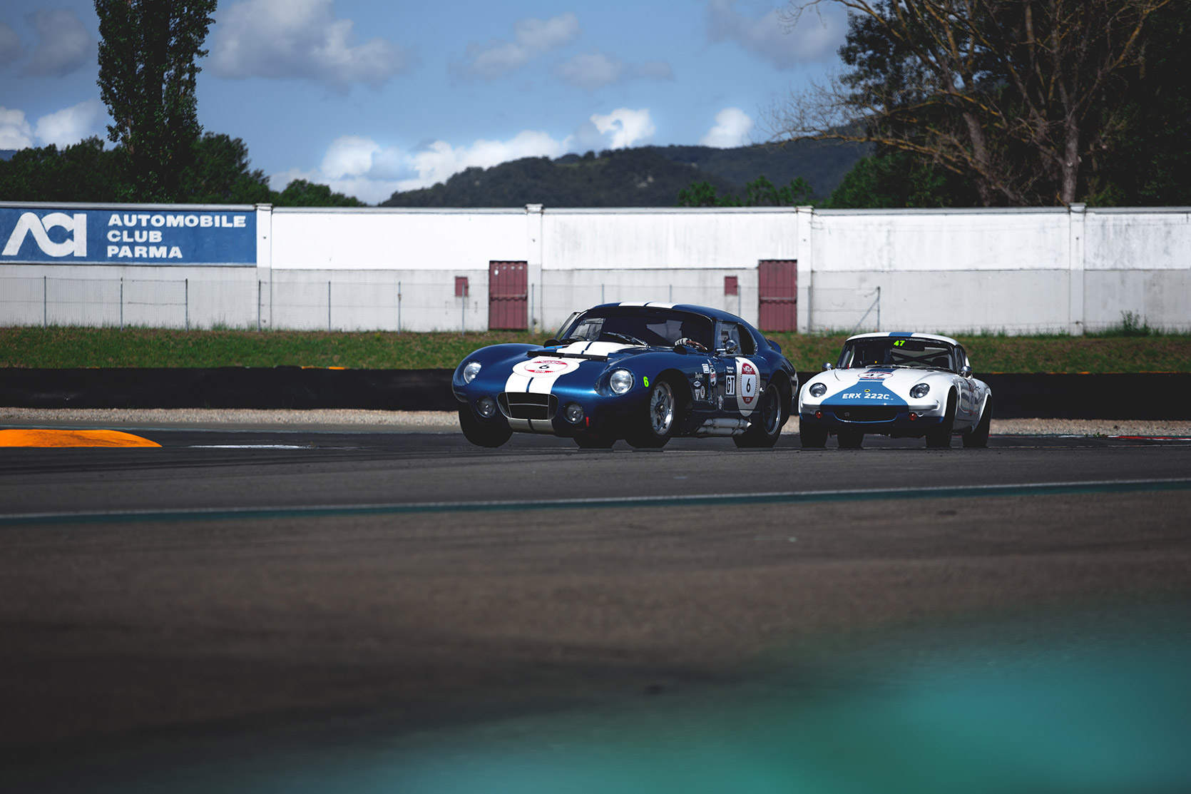 A Shelby Cobra Daytona Coupe chased by A Lotus Elan 26R in Autodromo Varano De Melegari at Modena 100 Ore